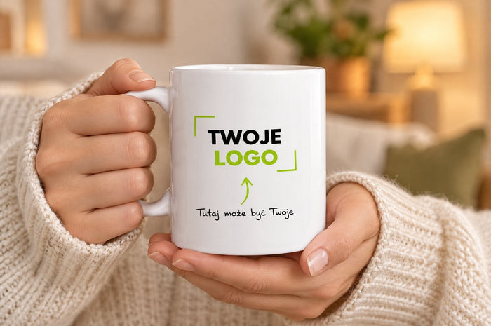 Dłonie trzymają biały kubek z napisem „Twoje logo”
