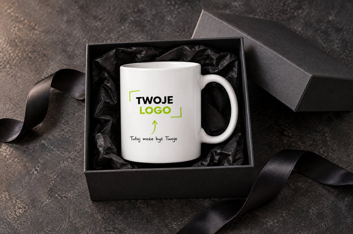 Kubek z logo w ciemnym pudełku prezentowym z bibułą i wstążką
