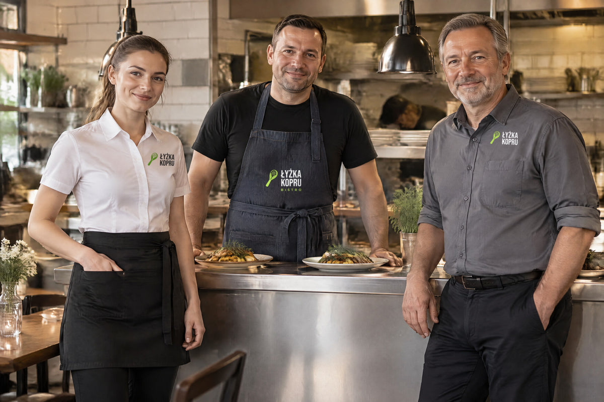 Wizualizacja AI: zespół fikcyjnego bistro Łyżka Kopru — kelnerka w białej koszuli JHK SHL POPSS i czarnej zapasce JHK WKVIENNA, kucharz w czarnej koszulce i jeansowym fartuchu JHK WKPARIS, kelner w szarej koszuli JHK SHA POP; przykładowe logo bistro na koszulach i na fartuchu.