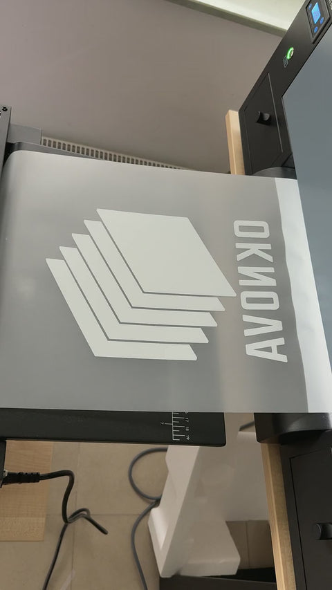 Drukarka DTF drukuje białe logo na folii transferowej
