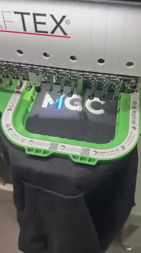 Hafciarka wyszywa logo MGC na czarnej odzieży